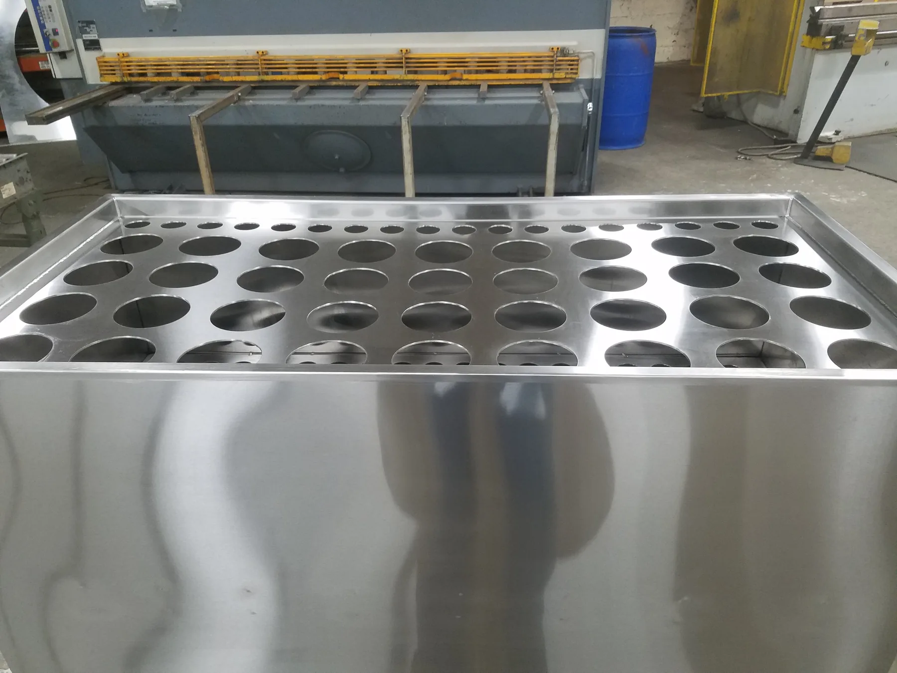 Finished stainless steel fabricated component with circular openings